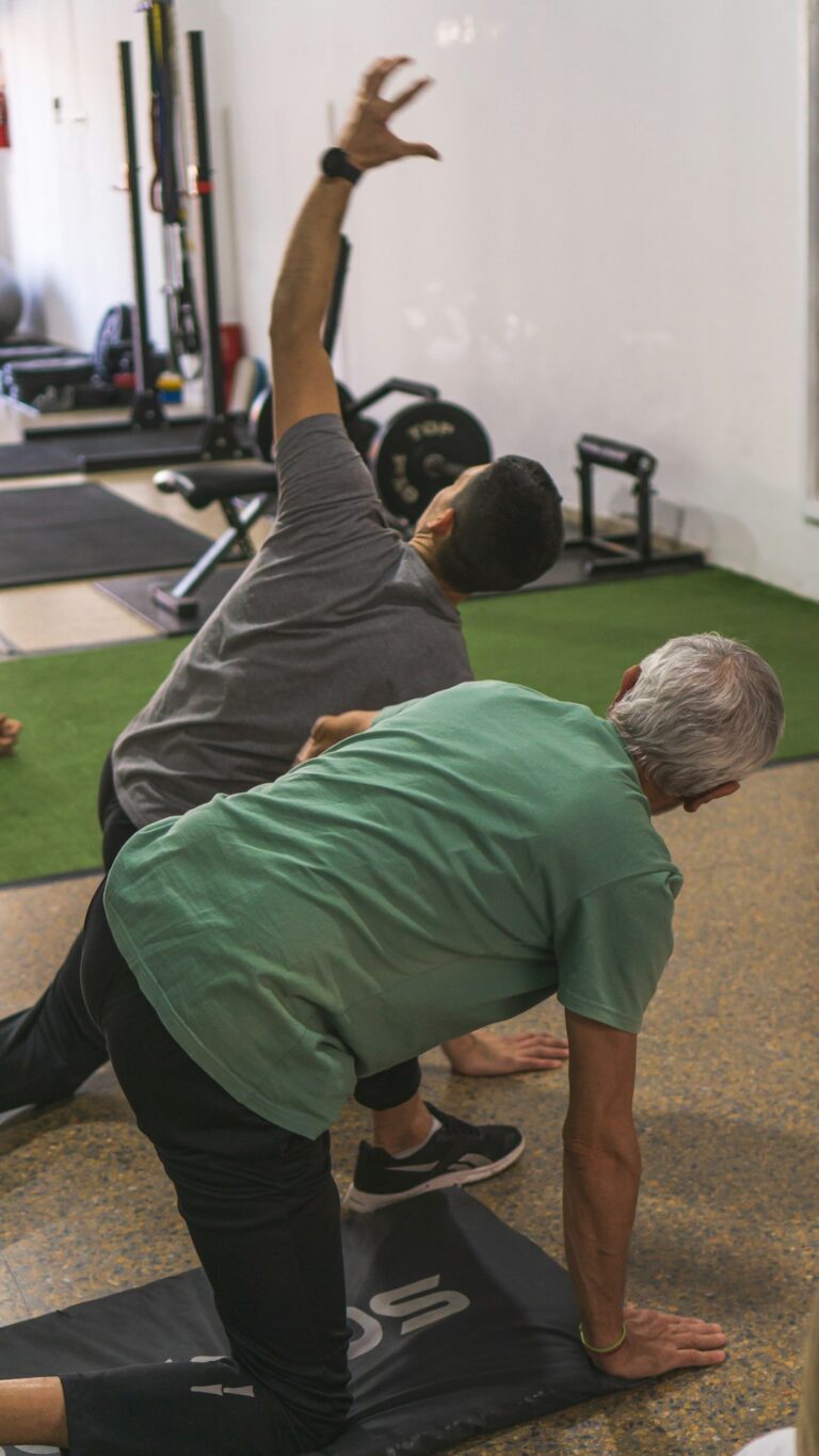 Older adult performing gentle knee exercises beside a chair with a resistance band nearby.